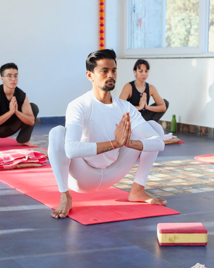 A diverse group of people practicing yoga and meditation indoors with focused concentration.