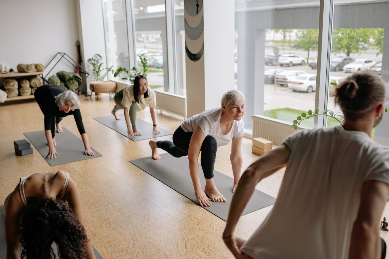 Adults practicing yoga indoors, focusing on mindfulness and flexibility exercises.